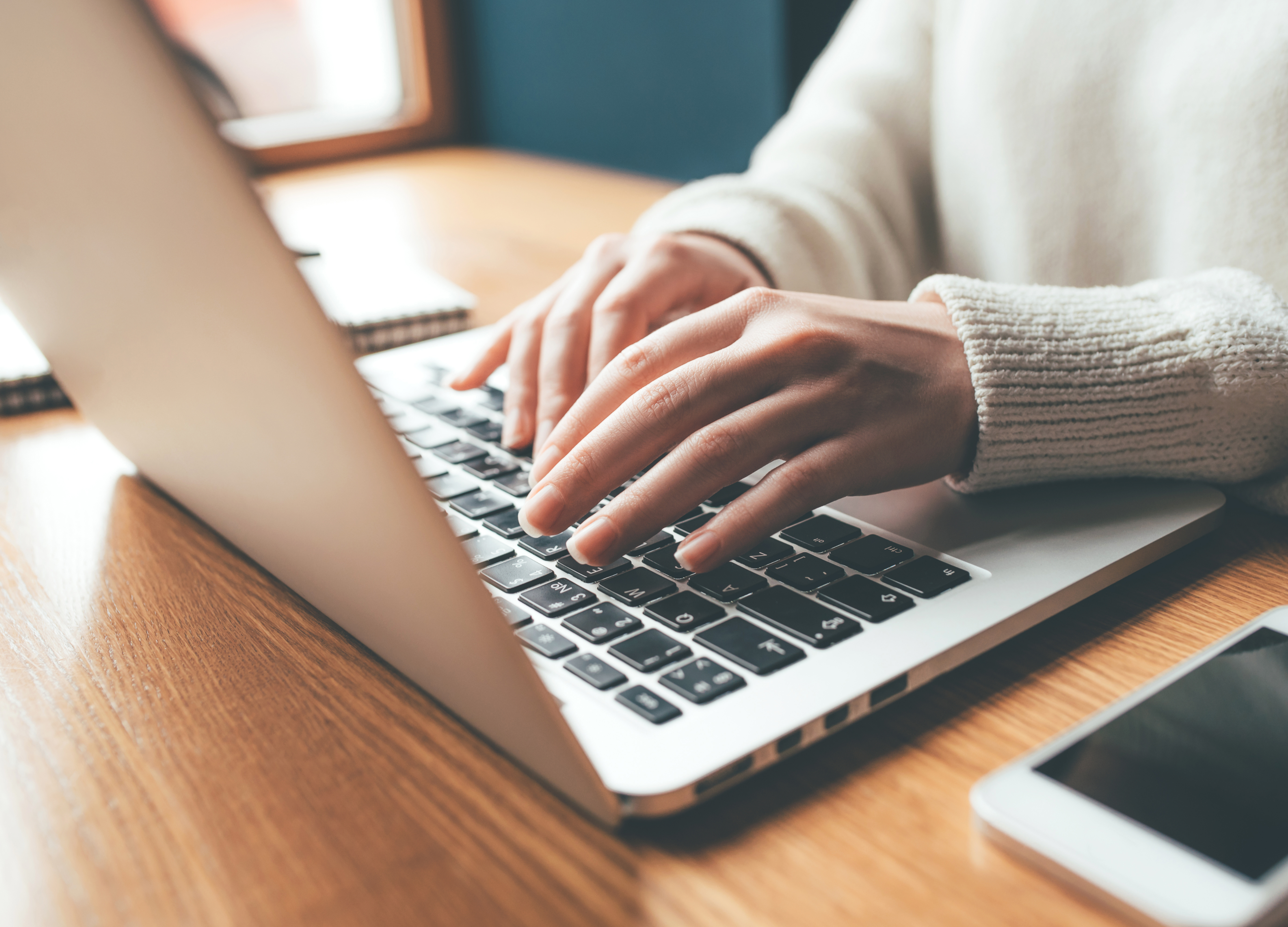 laptop and hands someone typing on a laptop