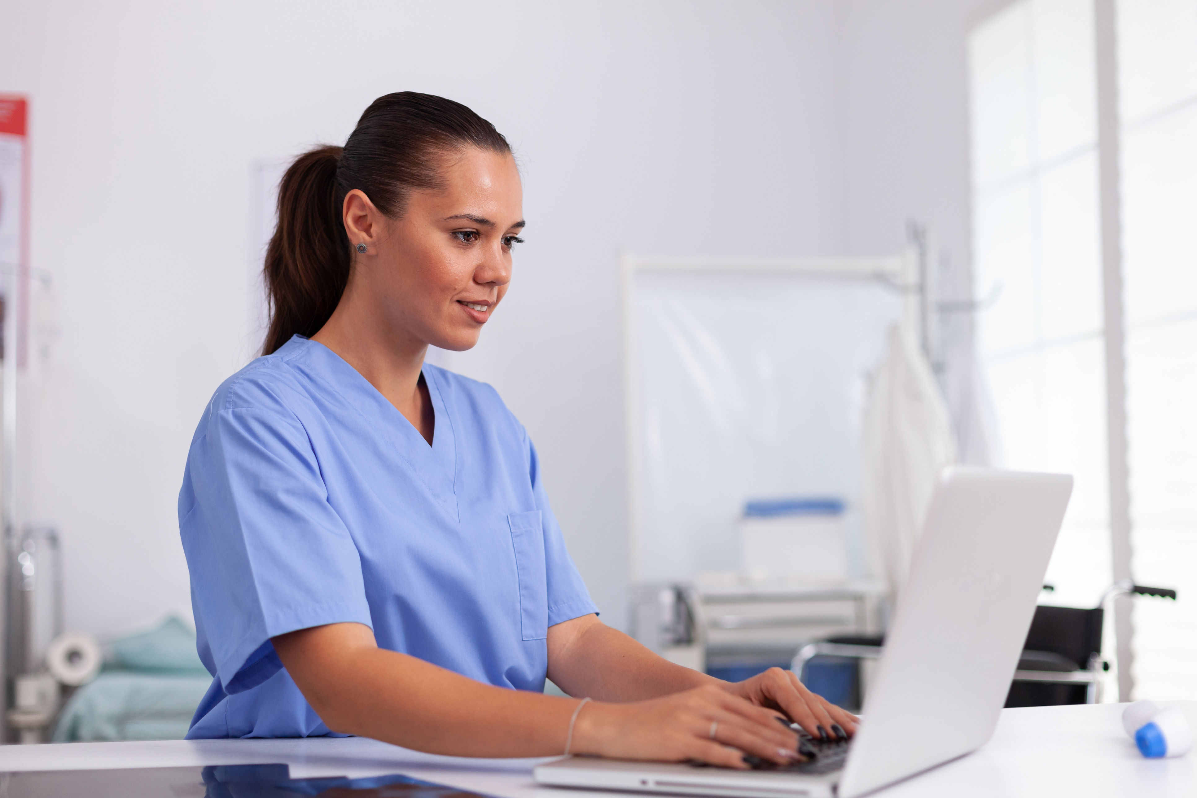 Medical assistant at desk typing
